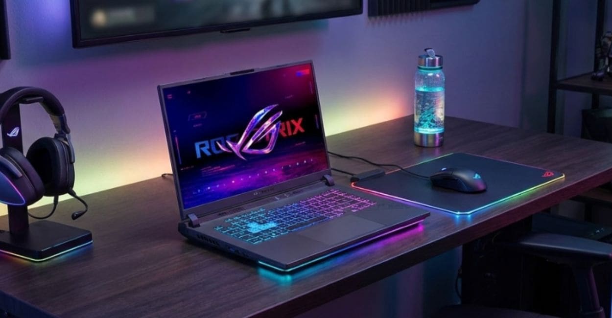 Notebook gamer sobre escrivaninha de quarto, com mousepad iluminado, mouse e headset em suporte